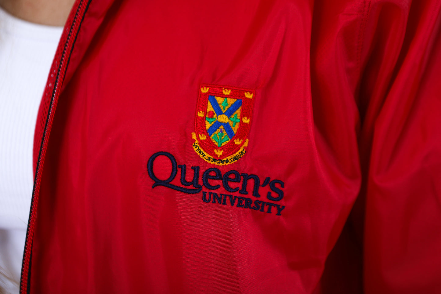 Close up of red zip up rain jacket with red Queen's crest logo